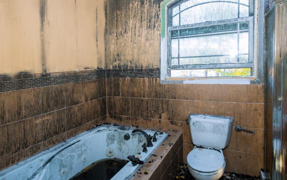a dirty bathroom with a tub, toilet and window